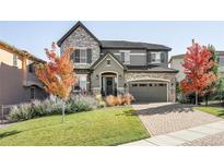 Charming two-story home with stone accents, manicured lawn, and a brick driveway at 6938 E Lake Dr, Centennial, CO 80111