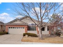 Ranch style home with brick and siding exterior, two-car garage, and mature landscaping at 9640 Silver Hill Cir, Lone Tree, CO 80124