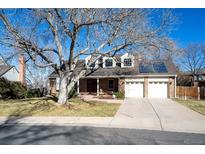 Charming brick home with a two-car garage, mature trees, and solar panels at 8274 S Jackson St, Centennial, CO 80122