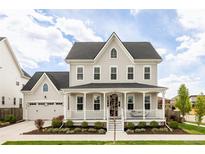 Charming two-story home featuring a welcoming front porch and attached two-car garage at 10106 E 59Th Pl, Denver, CO 80238