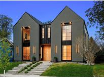 Modern home featuring a gray stucco exterior, large windows, black trim, and a landscaped front yard at 2376 S Bannock St, Denver, CO 80223