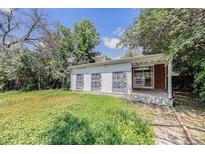 Backyard with grassy area and covered patio, offering outdoor living space at 387 Tucson St, Aurora, CO 80011