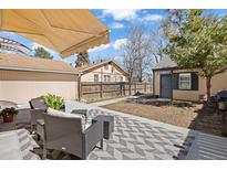 An outdoor patio with stylish furniture, a grill and a storage shed in the backyard create the perfect space for outdoor living at 1343 Valentia St, Denver, CO 80220