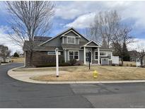 Charming two-story home with a well-maintained lawn and a combination of siding and stone accents at 6348 Deframe Way, Arvada, CO 80004