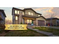 Charming two-story home featuring stone accents, a covered porch, and a well-maintained front yard at 14102 Night Owl Ln, Parker, CO 80134