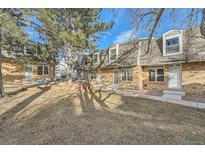 Brick townhouse exterior with landscaping and a tree at 1517 S Owens St # 7, Denver, CO 80232