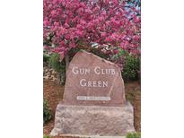 Stone entrance sign reading 'Gun Club Green,' with blooming trees in the background at 8101 E Dartmouth Ave # 22, Denver, CO 80231
