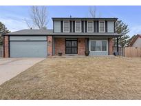 Charming two-story home boasts a well-maintained lawn, brick accents, and a welcoming entrance at 18982 E 46Th Ave, Denver, CO 80249