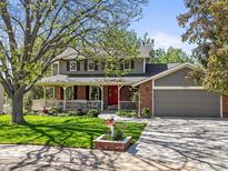 Charming two-story home featuring a welcoming front porch and well-manicured lawn at 6862 Independence Ct, Arvada, CO 80004