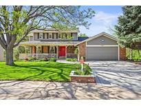 Charming two-story home with a landscaped front yard, covered porch, and inviting red front door at 6862 Independence Ct, Arvada, CO 80004