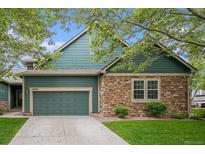 Charming two-story home with a blend of stone and blue siding, plus an attached two-car garage and well-maintained lawn at 11862 W Stanford Pl, Morrison, CO 80465