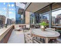 Relaxing balcony area with ample seating and a view of the surrounding city buildings and architectural features at 2100 16Th St # 600, Denver, CO 80202