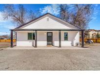 Charming home featuring black trim, a covered porch, and ample gravel parking at 801 S Leyden St, Denver, CO 80224
