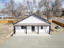 Aerial view of a quaint home with covered porch and generous gravel driveway at 801 S Leyden St, Denver, CO 80224