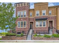 Charming townhome features brick facade, landscaped front yard, and inviting entry steps with iron railings at 9424 Ridgeline Blvd # I, Highlands Ranch, CO 80129