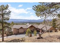 Expansive ranch style home with mountain views and a spacious front yard and driveway at 12653 Rancho Ct, Conifer, CO 80433