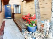 Inviting front porch with blue door and red Adirondack chairs creating a warm, welcoming entrance at 29983 Hilltop Dr # 2, Evergreen, CO 80439