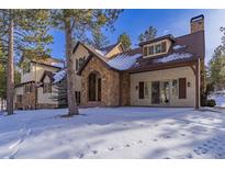 Stunning two-story home with stone accents and snowy landscape at 590 Cumberland Rd, Larkspur, CO 80118