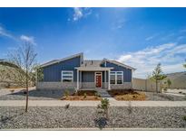 Charming home featuring a blue exterior, stone accents, landscaped front yard and a pop of color with the red front door at 5150 N Quemoy Ct, Aurora, CO 80019