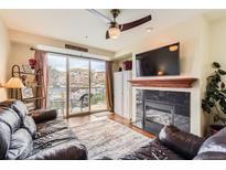 Inviting living room featuring a cozy fireplace and sliding glass doors to private balcony at 9019 E Panorama Cir # D207, Englewood, CO 80112