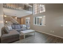 Inviting living room featuring modern gray tones, hardwood floors, and a large window at 11894 Elk Head Range Rd, Littleton, CO 80127
