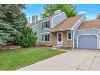 Charming home with stone accents, blue siding, and a well-maintained front yard and driveway at 19421 E Milan Cir, Aurora, CO 80013