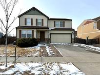 Two-story home featuring a front yard, neutral siding, attached two car garage and some bare trees at 10117 Granby St, Commerce City, CO 80022