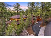 Beautiful exterior view of a home with a driveway and surrounded by lush trees and landscaping at 67 Indigo Way, Castle Rock, CO 80108