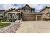 Charming two-story home featuring a stone-accented porch and a spacious three-car garage at 15705 Red Deer Dr, Morrison, CO 80465