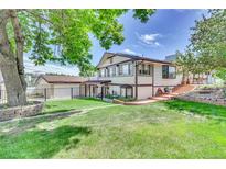 Ranch style home with landscaped yard, detached garage, and spacious backyard at 7475 W Kentucky Ave, Lakewood, CO 80226