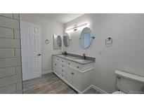 Bright bathroom featuring a dual sink vanity with granite countertop and modern fixtures at 100 E Highline Cir # 307, Centennial, CO 80122