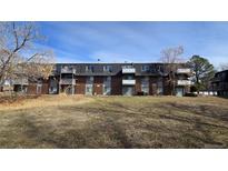A multi-Gathering brick apartment building with balconies surrounded by a lawn and trees at 100 E Highline Cir # 307, Centennial, CO 80122