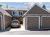 Exterior view of townhome with attached garage, driveway and lush landscaping at 7474 E Arkansas Ave # 17-07, Denver, CO 80231