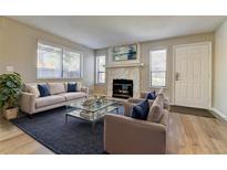 Inviting living room features a cozy fireplace and lots of natural light from the windows at 9501 W 89Th Cir, Broomfield, CO 80021