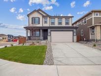 Beautiful two-story home with a well-manicured lawn and a two-car garage at 45909 Wood Thrush Ave, Bennett, CO 80102