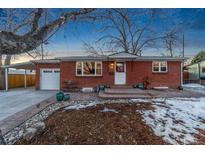 Brick ranch home with attached garage, landscaping, and covered carport at 5107 Johnson St, Arvada, CO 80002