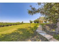 Expansive backyard featuring stone walkway, lamp post, mature trees, and lush landscaping at 34 S Raleigh St, Denver, CO 80219