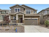 Charming two-story home featuring stone accents, neutral siding, and an attached two-car garage at 28625 E 6Th Pl, Watkins, CO 80137
