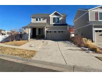 Two-story house with beige siding, attached garage, and landscaping at 5572 Killarney St, Denver, CO 80249