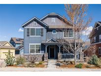 Charming two-story home with stone accents, a covered front porch, and manicured landscaping at 2879 Shadow Lake Rd, Lafayette, CO 80026