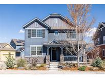 Charming two-story home with blue siding, stone accents, covered porch, and well-maintained landscaping at 2879 Shadow Lake Rd, Lafayette, CO 80026