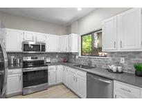 Well-equipped kitchen with stainless steel appliances, ample counter space, and modern finishes at 10693 W 63Rd Dr # 106, Arvada, CO 80004