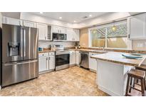Bright kitchen with stainless steel appliances, tile backsplash, and countertops at 2891 S Vaughn Way, Aurora, CO 80014