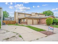 Charming two-story home with a two car garage, brick accents, and a well maintained front yard at 12702 Fairfax St, Thornton, CO 80241