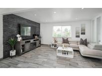 Bright living room featuring a stone accent wall, fireplace, and contemporary furnishings at 772 Lewiston St, Aurora, CO 80011