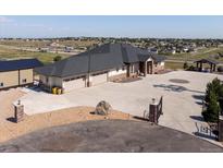 Stunning single-story home featuring an extra garage, circular driveway, rock landscaping, and neutral color palette at 14025 Florence Ct, Brighton, CO 80602