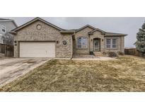 Charming brick home featuring an attached garage and manicured front yard in a quiet neighborhood at 17423 Cornerstone Ln, Parker, CO 80134