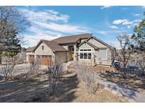 Charming exterior of a stone-clad home featuring a three-car garage and inviting walkway at 4249 Oak Grove Way, Castle Rock, CO 80108