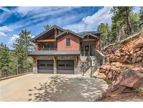 Stunning modern two-story home with a two-car garage and beautiful stone accents nestled on a hillside at 795 Pine Brook Rd, Boulder, CO 80304