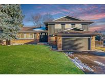 Inviting two-story home featuring a well-manicured lawn, brick accents, and an attached two-car garage at 7649 E Amherst Ave, Denver, CO 80231